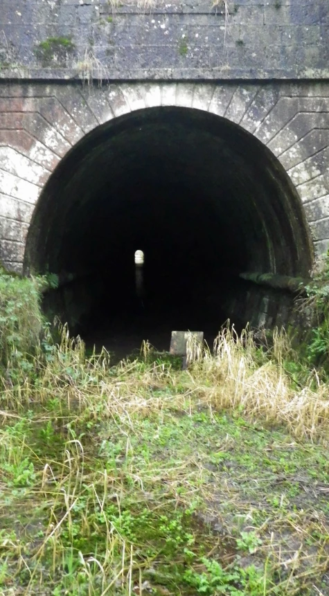 a gray stone tunnel with an overhang