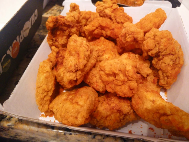 chicken bites sitting in a box, on top of a counter