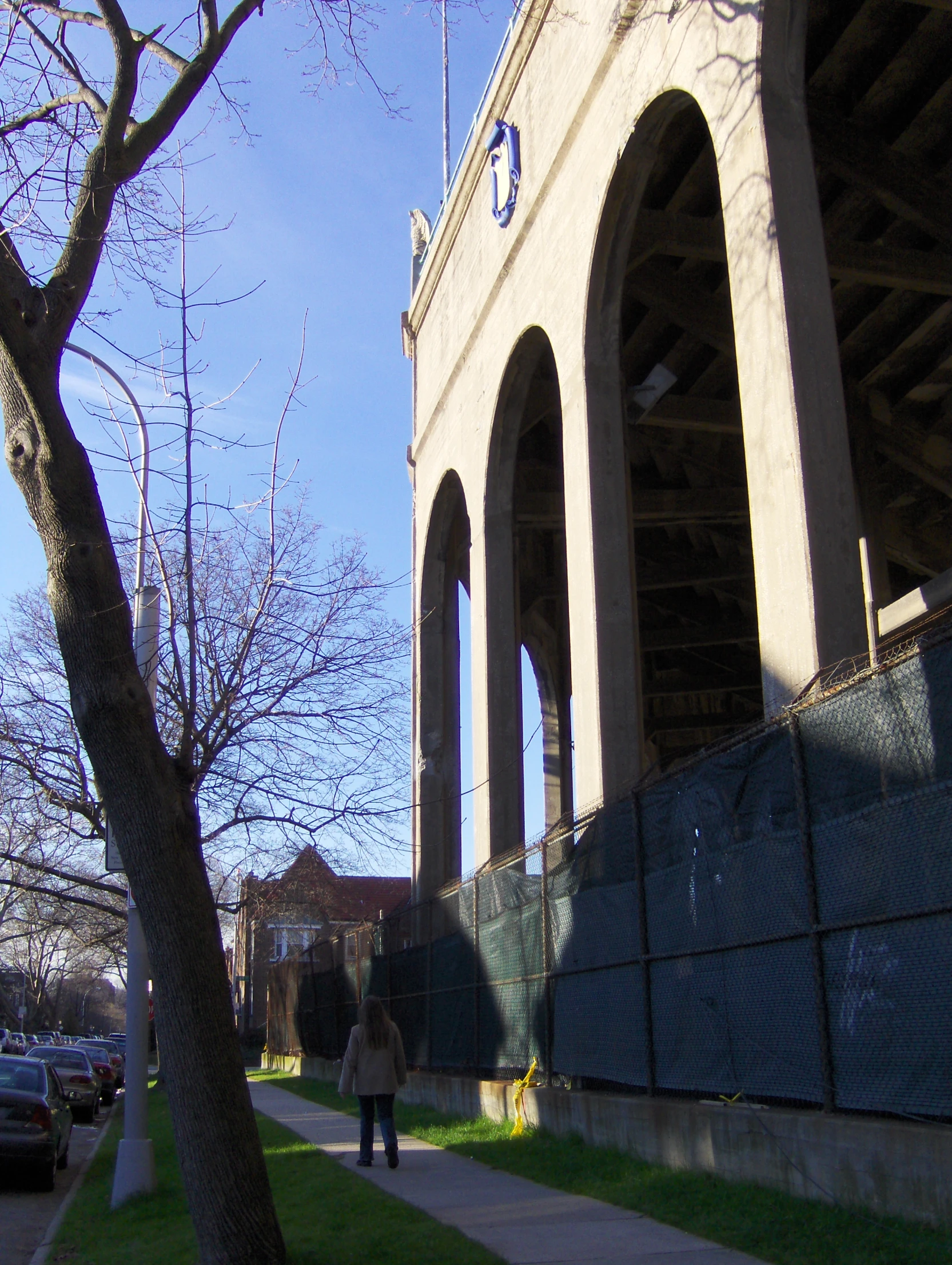 a girl walks down a sidewalk between two arches