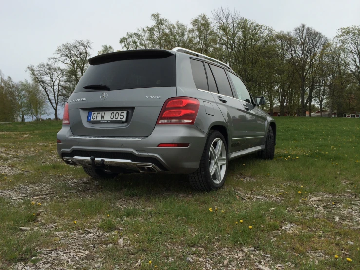 a large grey vehicle parked on a grass covered field