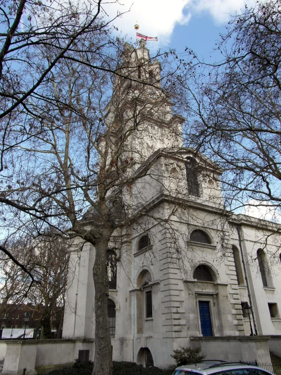 a church with a tall steeple with a blue door