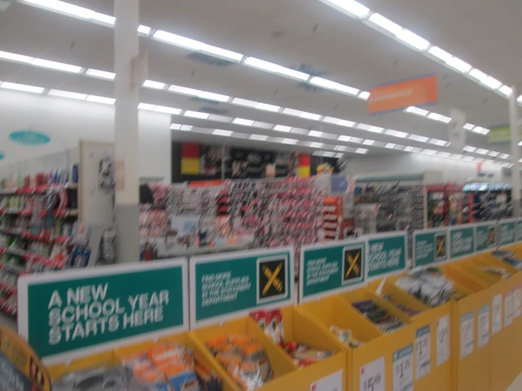 a very long supermarket with several green signs