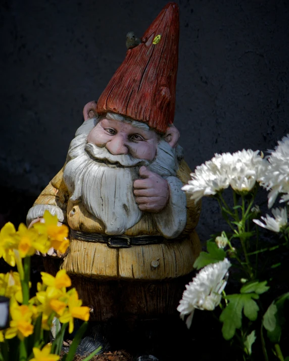 a statue of an old man holding soing up to his face