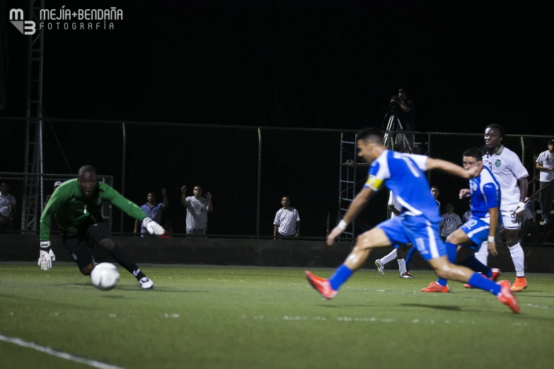 a group of men on the soccer field playing ball