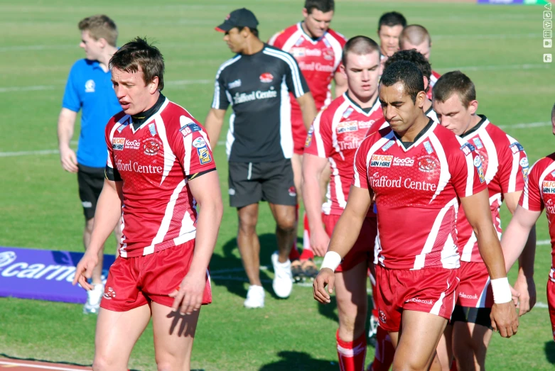 men wearing uniforms that are red and white on the field