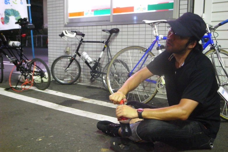 a man sitting next to a group of bikes