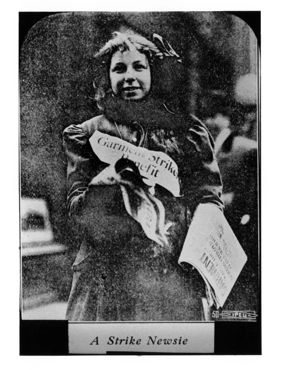 an old black and white picture of a girl holding a sign