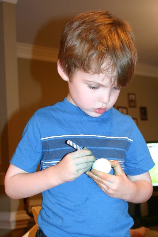 a little boy is fixing soing in his mitt