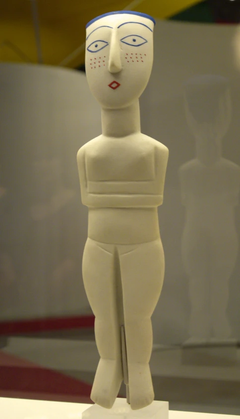 a small plastic figure standing on display in a museum