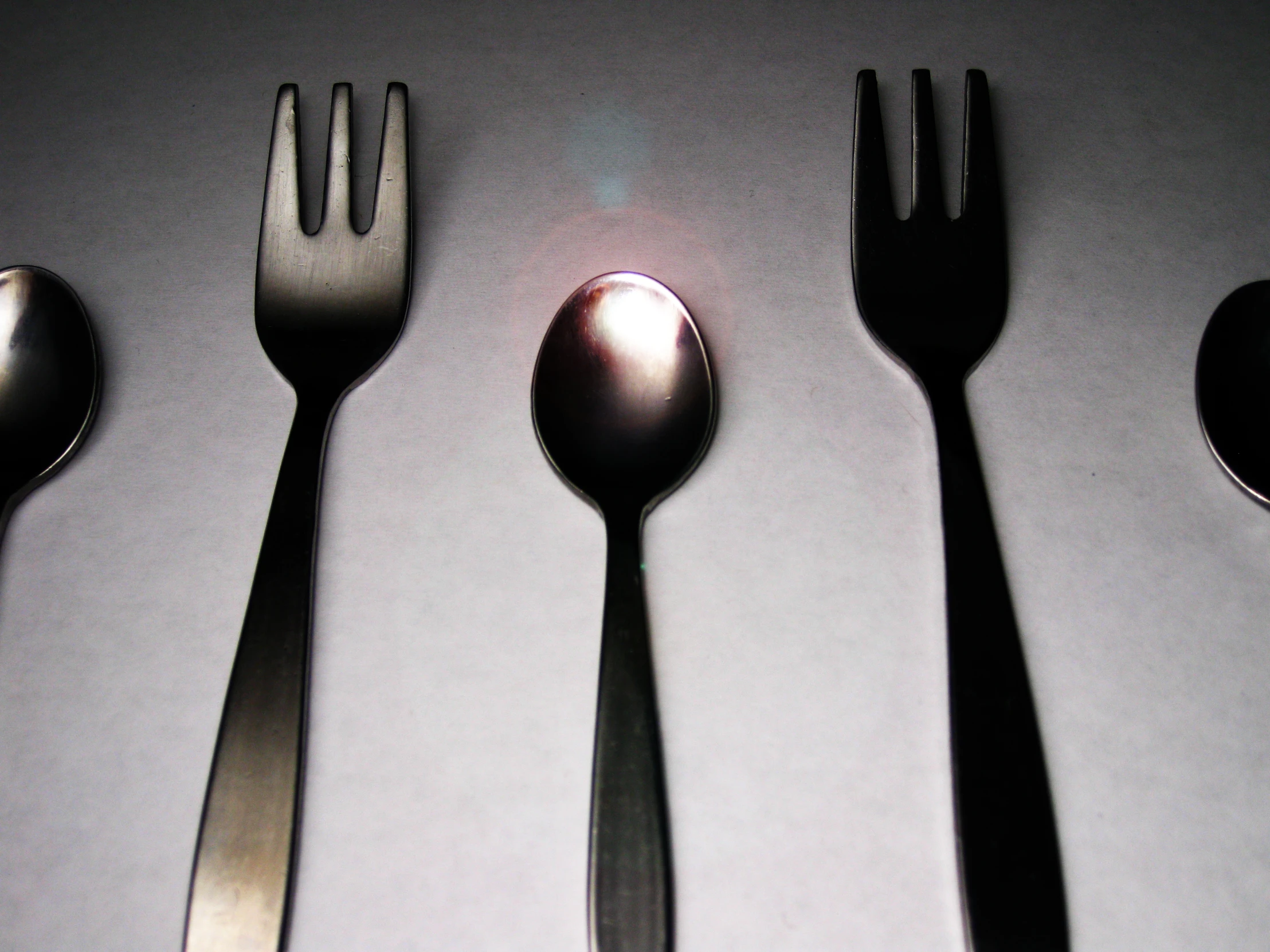 spoons, fork and knife sitting on top of a table