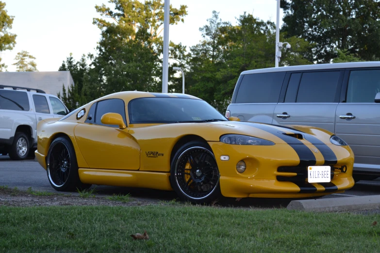 a yellow dodge sr bug parked in a parking lot