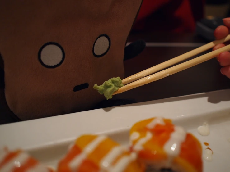 person eating food with chopsticks at a table