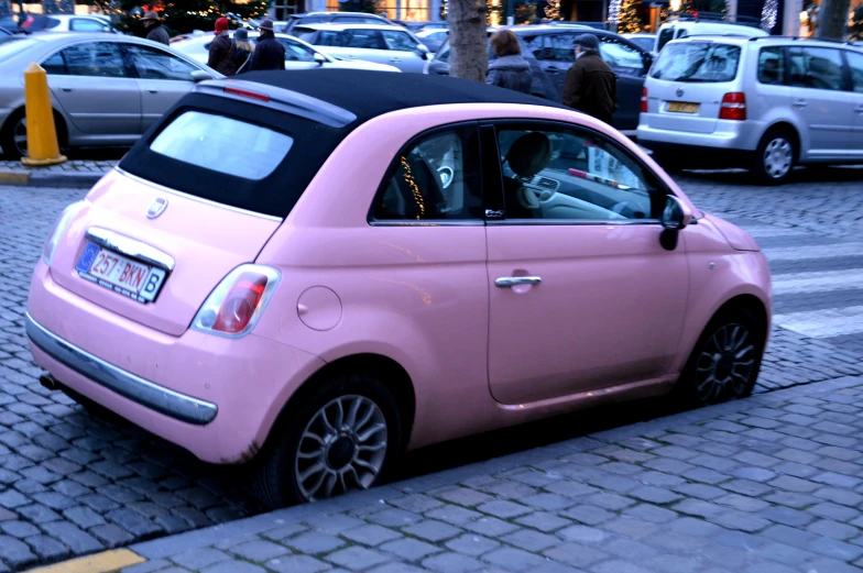 an image of a little pink car parked on the street