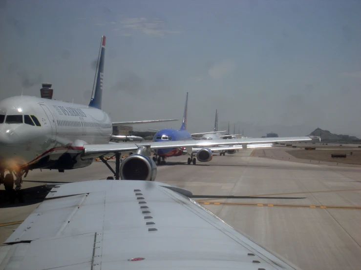 several passenger jets in an airport getting ready to take off