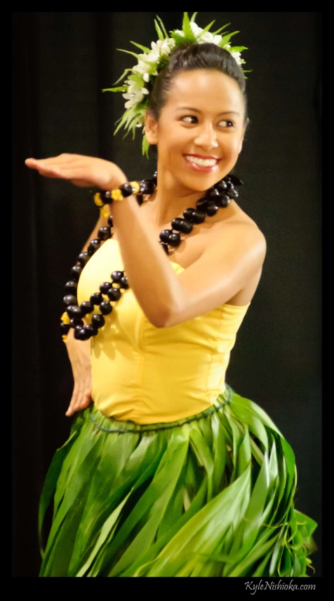 a beautiful woman in grass skirt holding an item