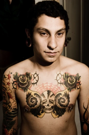 a man with tattoos on his chest and shoulder