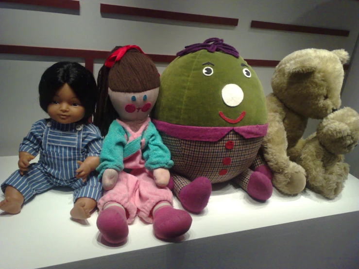 several stuffed animals, two dolls, one brown teddy bear