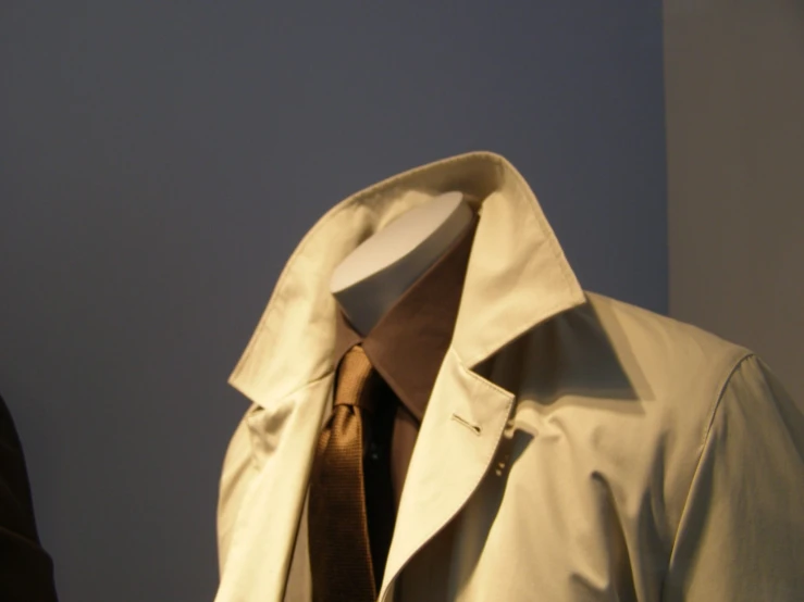 white coat with a brown tie in front of a mannequin