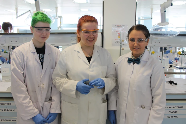 three young women with green hair standing together