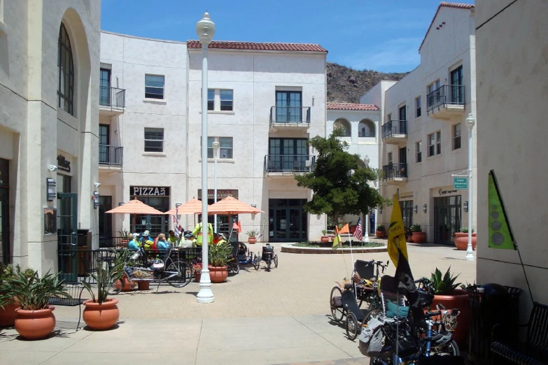 a city courtyard with bicycles parked in rows and potted plants