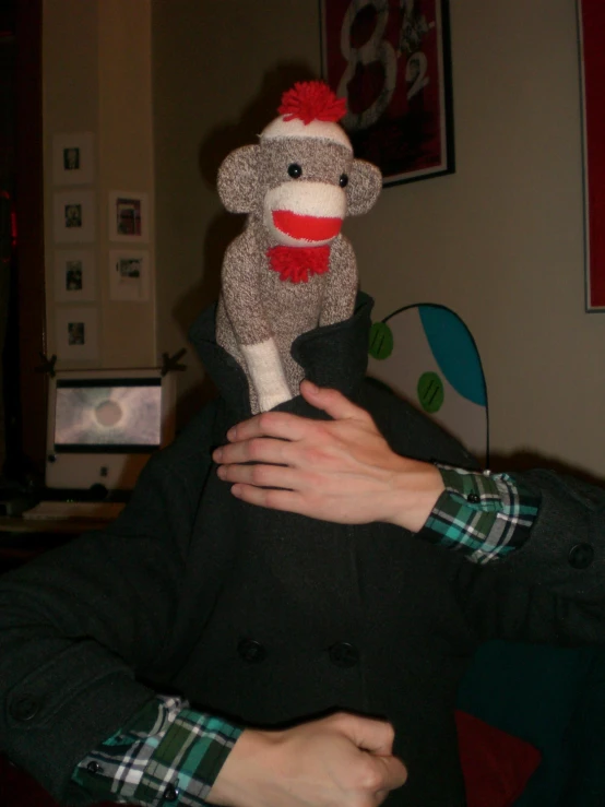 the man has his hand on the stuffed monkey