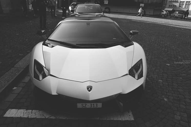 a white sports car is parked on the side of the road