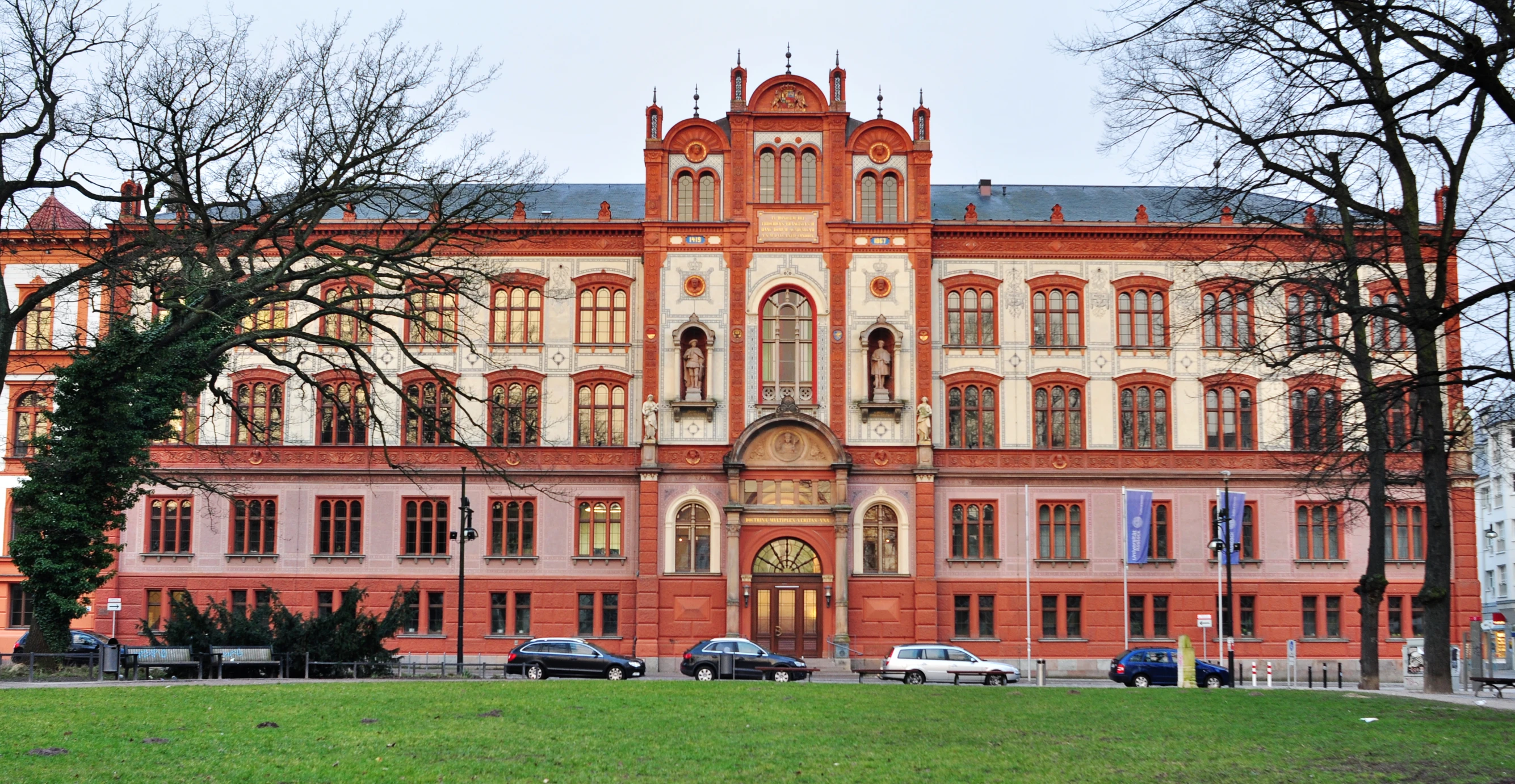 a very big building with cars parked in front of it