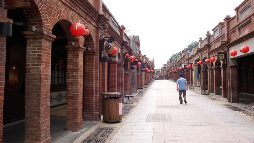 a man walking through a deserted shopping district