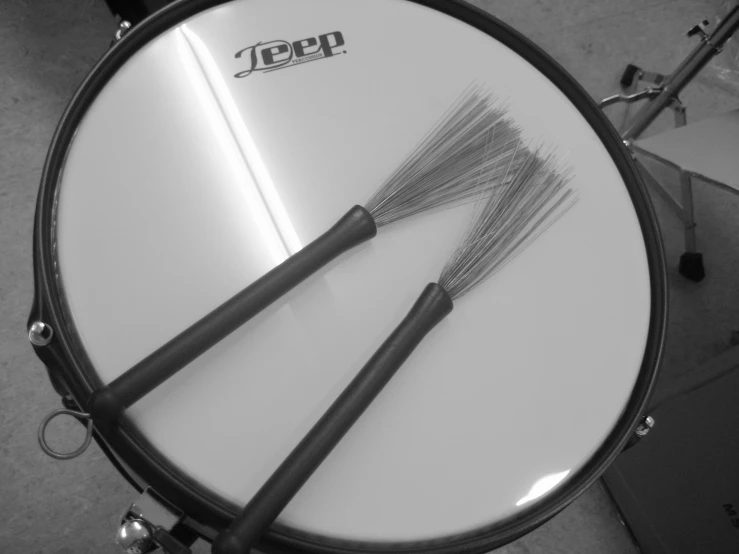 a drum kit with two large metal brushes