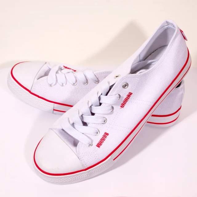 a pair of white canvas tennis shoes with red lettering