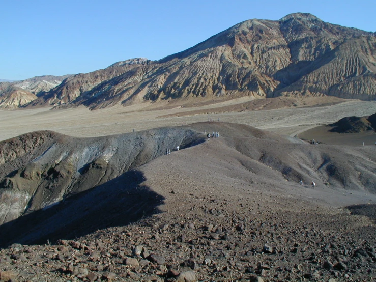 several people standing on top of a mountain with mountains in the background