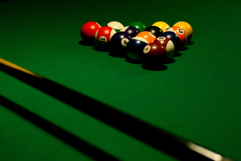 billiards balls and rackets in the shadows on a pool table
