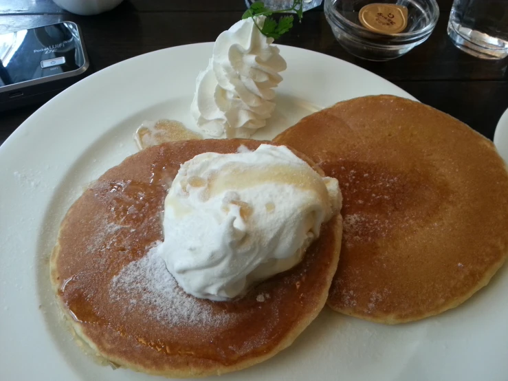 a plate with pancakes and whipped cream on it