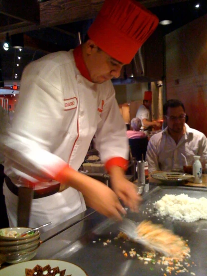 the man in the chef hat is slicing some food