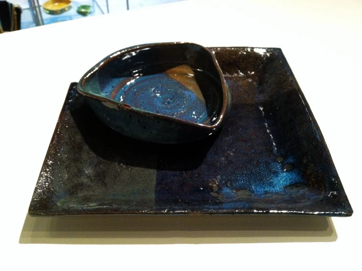 black ceramic bowl with blue decoration in center