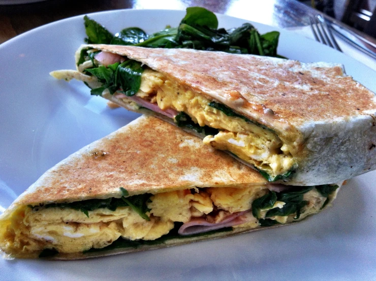 a sandwich on a plate with spinach