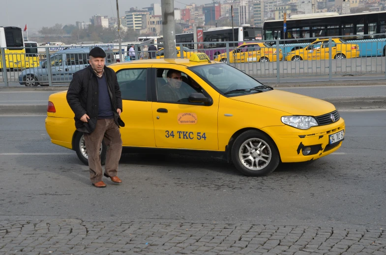 a man is leaning against his cab, waiting to get a ride