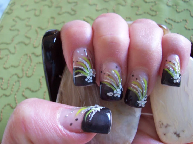an artistic nail art design using flowers on black