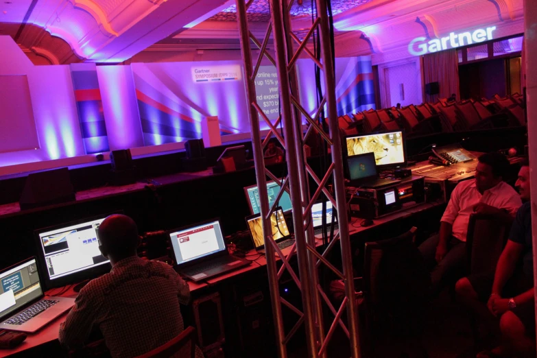 a man in a room with multiple computers and screens