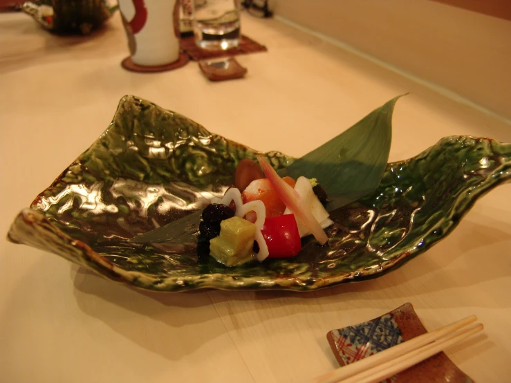 a small green bowl filled with a sushi