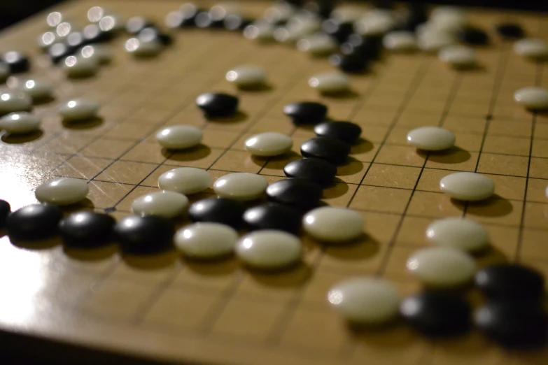 an oriental board game is seen with several white and black pieces
