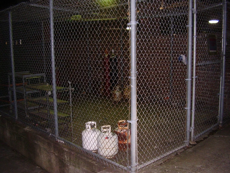 two containers are in the middle of a fenced area