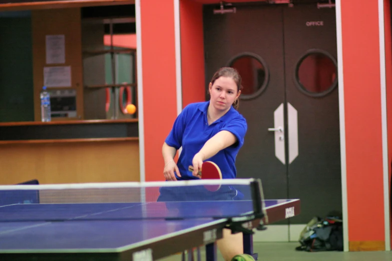 there is a woman in the middle of the table playing ping pong