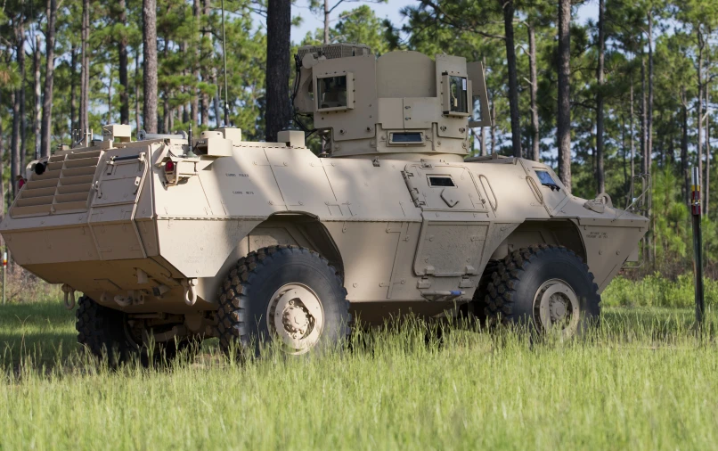 a big, army green armored vehicle parked on the ground