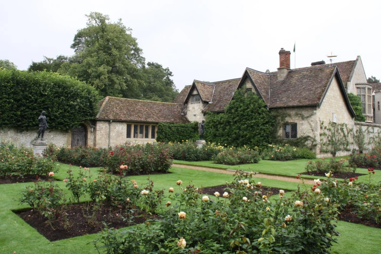 an old house with flowers in the front yard