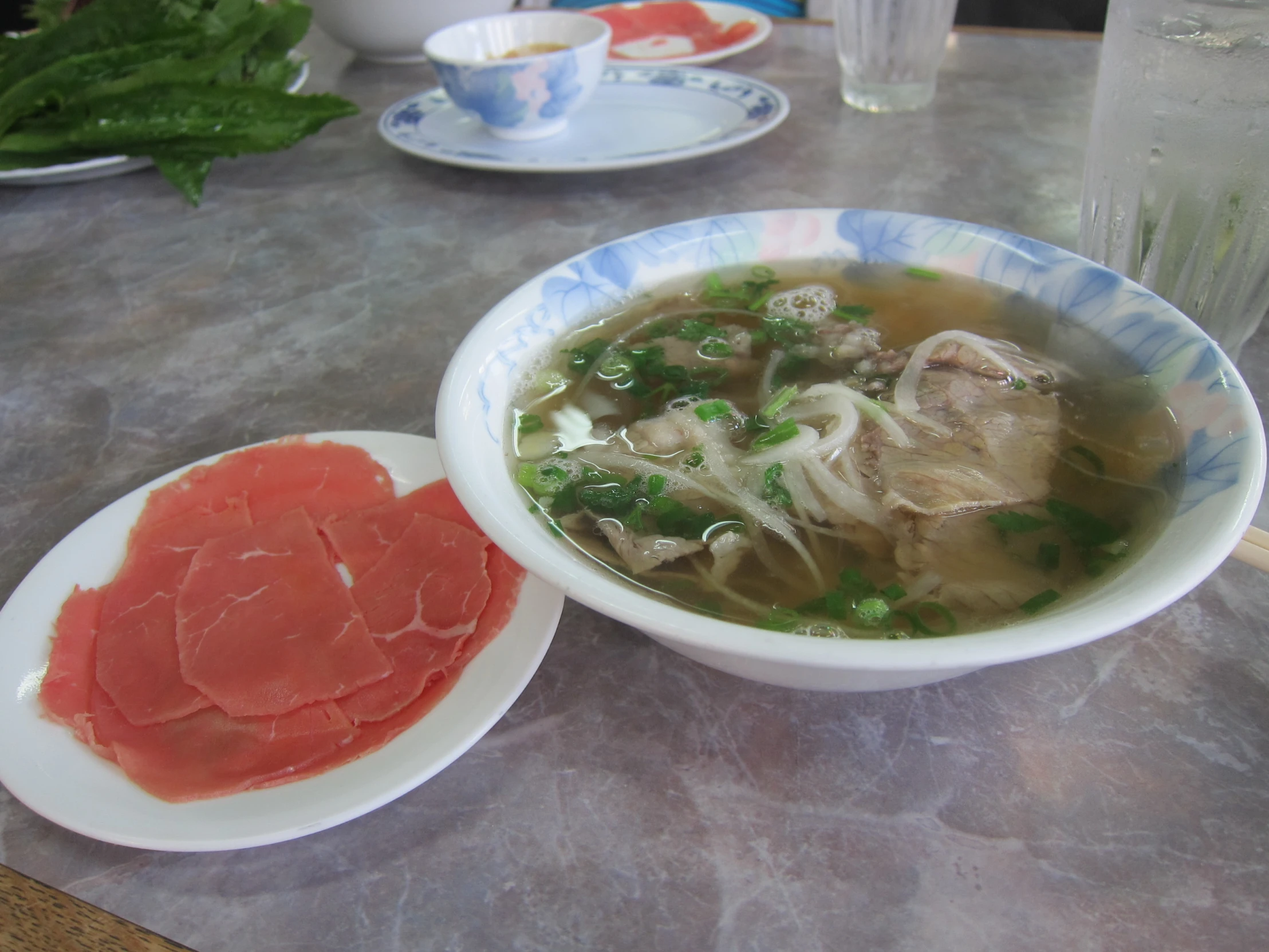 a soup bowl sits on a table, surrounded by other foods