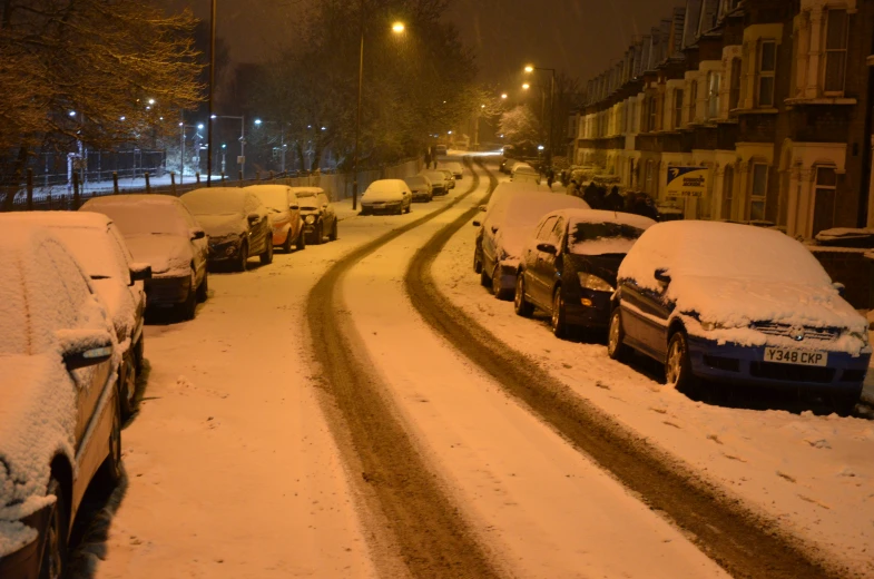 cars parked along a street on snow covered roads