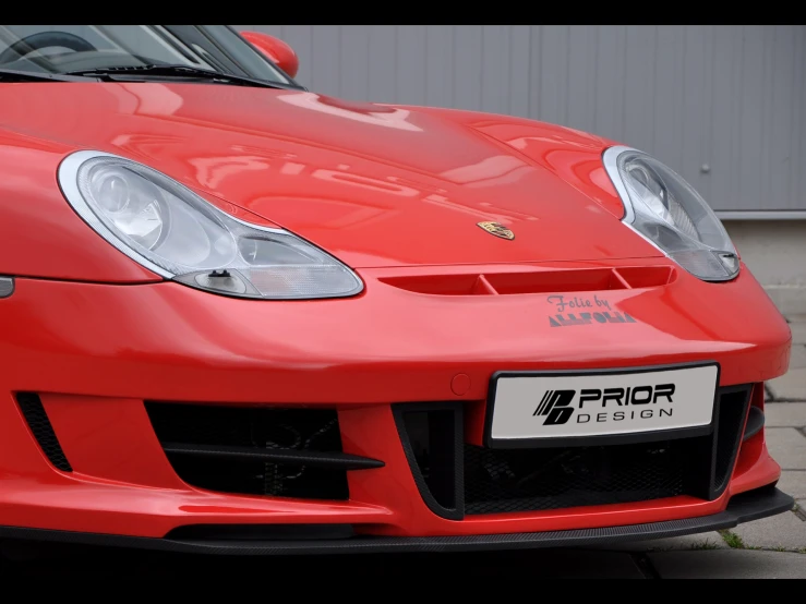 red porsche car in front of a grey garage