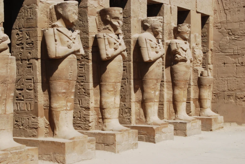 a couple of statues are sitting on the side of a building