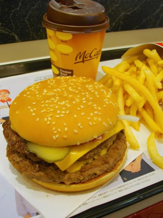 a cheeseburger with fries, a cup and a soda